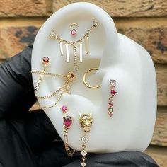 a person holding up a fake earring holder with jewelry on it's side