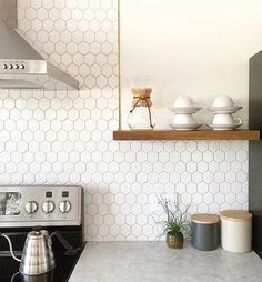 a stove top oven sitting inside of a kitchen next to a wall mounted range hood