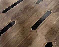 a wooden floor with black marble inlays