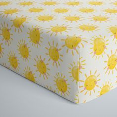 a yellow and white bed sheet with sun designs