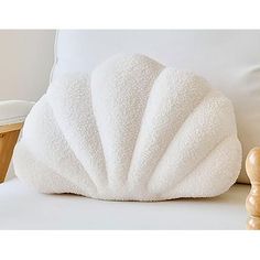 a white pillow sitting on top of a bed