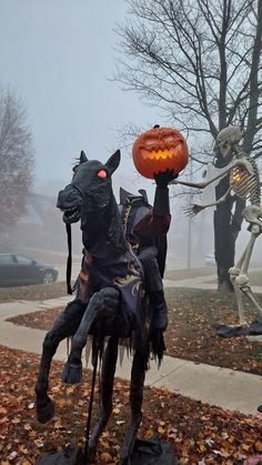 two halloween statues in the middle of a yard