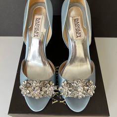 a pair of blue high heeled shoes with crystal embellishments on the toes