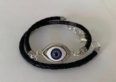 Wrap bracelet, Leather wrap bracelet, Boho bracelet, Women's leather bracelet, Bohemian jewelry, Fashion jewelry, Evil eye bracelet Color: black Material: 1 row braided (4mm) leather cord rope that wraps around the wrist twice, toggle clasp, silver plated tree charm Handmade Thank you for considering my listing View more items https://www.etsy.com/shop/ANIJbyAniko?ref=l2-shopheader-name&section_id=20780826 Bohemian Adjustable Eye-shaped Jewelry, Adjustable Bohemian Eye-shaped Jewelry, Bohemian Eye-shaped Adjustable Jewelry, Jewelry Evil Eye, Leather Bracelets Women, Bracelet Leather, Boho Bracelet, Bracelet Boho, Eye Bracelet