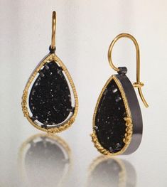 From Elizabeth Garvin's Spiral Collection, these #4 natural prong-set black druzy teardrop earrings in 18k gold are backed with oxidized sterling silver and feature surrounding natural yellow diamonds. As with every one of Ms Garvin's pieces, they are hand fabricated with hammer texturing. Earrings have 3/4" drop (1 1/4" with ear wires) and are 1/2" wide. The 18k yellow gold locking ear wires offer added security. Hand fabricated, hammer textured. Price is $1895. Elizabeth Garvin is known for her award winning bold signature style. She has operated out of her NYC studio since 1980. Elizabeth is both self-taught and a 1986 graduate of NYU, Parsons School of Design & Mass College of Art. A lifetime of studying stones, plants and ocean currents gives her beautifully melded pieces a modern sen