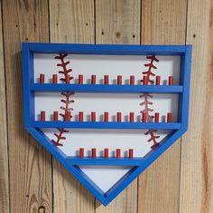 a blue shelf with baseballs and candles in it on a wooden wall next to wood planks