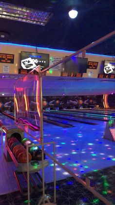 a bowling alley filled with bowling balls and neon lights