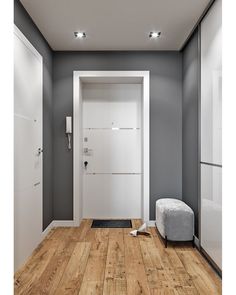 an empty room with a white door and wooden floor