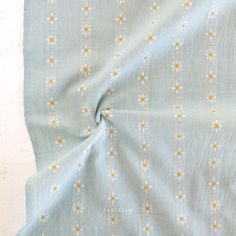 the fabric is blue with yellow and white flowers on it, as well as an orange flower