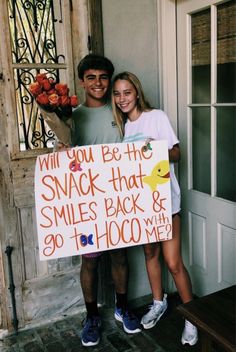 a man and woman standing next to each other holding a sign that says will you be the snack that smiles back & 90th hoo