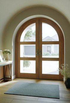 an arched wooden door with glass panes