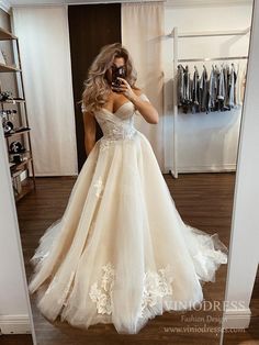 a woman in a wedding dress taking a selfie with her cell phone while standing in front of a mirror