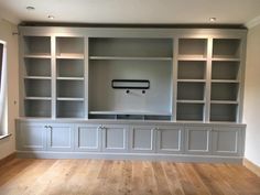 an empty living room with built in bookshelves