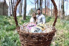 a man and woman standing next to each other in a basket filled with candy eggs