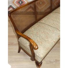 a wooden bench sitting on top of a hard wood floor next to a rug and pillow