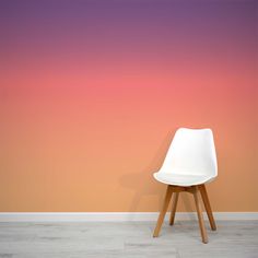 a white chair sitting on top of a hard wood floor next to a pink and orange wall