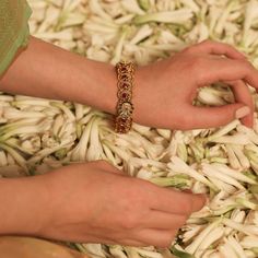 Description Crafted for special events, this antique gold-plated silver bangle is expertly designed with Kempu stones on a traditional Indian floral and peacock ensemble. The perfect companion to festive attire, the shine of its antique gold tone makes it irresistible and regal. Style with a necklace set from the Mandira collection for a grand look. Product Information Materials used: 925 Silver with 1.0-microns Antique Gold Plating Stones: Semi precious stones Length: 6(2.6) cm Contains: Comes 22k Gold Jewelry For Puja, Hand Set 22k Gold Festive Bracelets, Elegant Cutdana Bracelets For Navratri, Elegant Beaded Bracelets For Navratri, Traditional Navratri Bangle Jewelry, Traditional Bangle Jewelry For Navratri, Traditional Bangle For Navratri, Navratri Intricate Bangle Jewelry, Navratri Wedding Bracelet Jewelry