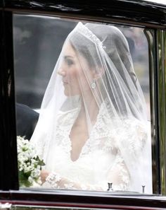 the bride is in her wedding car looking out the window at the groom and bride