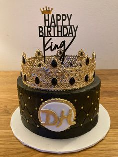 a black and gold birthday cake with a crown on top that says happy birthday king