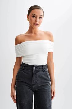 Your everyday staple. The MEENA Recycled Nylon Off-Shoulder Top seamlessly blends sustainability with style. Boasting an off-shoulder design and a ruched, foldover neckline, it adds texture and dimension to the look. With a slight bodycon fit, it flatters the silhouette while ensuring comfort. The cropped torso design introduces a playful element, making it a versatile piece suitable for various occasions. Crafted from recycled nylon, this top not only reflects a fashion-forward taste but also promotes a more sustainable wardrobe. Elevate your look with the chic Meena Off-Shoulder Top.