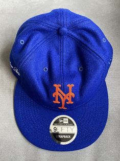 ALD x New Era wool 9FIFTY strapback hat in classic New York Mets blue with orange NY logo. Leather strap and Aime Leon Dore embroidered logo on the right side of the hat. ALD x New Era label on the inside of hat. Retro style green underbill. Short Brim Fitted Hat For Baseball Season, Short Brim Baseball Cap For Baseball Season, Blue Fitted Hat With Logo Patch And Flat Bill, Blue Snapback Hat With Logo Patch For Sports, Blue Flat Bill Fitted Hat With Logo Patch, Blue Sports Fitted Hat With Logo Patch, Blue Snapback Hat With Logo For Baseball Season, Blue Fitted Hat With Logo Patch For Sports, Blue Snapback Hat With Logo Patch