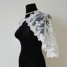 a mannequin wearing a white lace shawl on top of a black dress