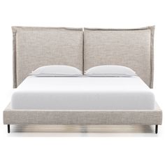 an upholstered bed with white sheets and pillows