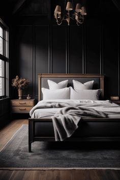 a bed with white pillows and blankets in a dark room next to a large window