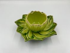 a green flower shaped bowl sitting on top of a table