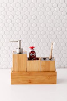 a wooden holder with two toothbrushes, soap and lotion bottles in it