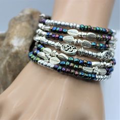 Fun and festive this seven layer bracelet is sure to make a fresh statement. The layered silver and colored beads give that fun boho vibe which will compliment nearly all outfits, and is perfect for everyday, beach vacations, or special occasions. #memorywirebracelet #handmade #statementjewelry #crystals #beads #bracelet #coilbracelet #jewelerydesign #jewelrydesigner #statementbracelet #jewelery #oneofakindjewelry #dramatic #handcraftedbracelets #fashion #love #pearls #style #wedding Festival Multicolor Bracelets With Silver Beads, Bohemian Silver Wrap Bracelet, Nickel Free, Silver Bohemian Wrap Bracelet Nickel Free, Nickel Free Silver Bohemian Wrap Bracelet, Nickel-free Silver Bohemian Wrap Bracelet, Bohemian Nickel-free Silver Wrap Bracelet, Nickel-free Multicolor Beaded Bracelets For Festivals, Multicolor Bohemian Beaded Bracelets With Silver Beads, Silver Spiritual Wrap Bracelet For Festivals