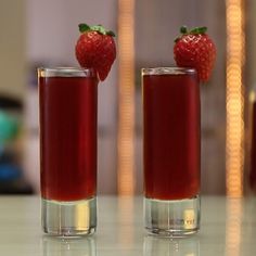 two glasses filled with liquid and a strawberry on top