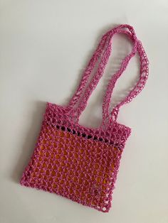 a pink and orange purse sitting on top of a white table