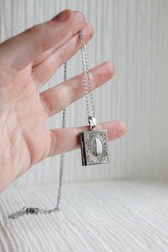 For our book lovers👀 This locket is a fully functional locket, so it opens and closes and you can add any keepsakes or photos inside to make it all the more meaningful! This necklace is made of solid stainless steel and is completely tarnish proof and high quality, so you know that means it's hypoallergenic and nickel free! This is the perfect gift for all our book lovers, writers, and academia girlies! This locket comes in with a 20 inch necklace chain. Engraved Stainless Steel Locket Necklace As Gift, Engraved Stainless Steel Locket Necklace For Gifts, Stainless Steel Locket Necklace Keepsake, Stainless Steel Locket Necklace For Keepsake, Stainless Steel Pendant Locket Necklace As Gift, Engraved Metal Locket Necklace For Keepsake, Nickel-free Silver Stainless Steel Locket Necklace, Stainless Steel Locket Pendant Necklace, Stainless Steel Locket Necklace