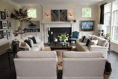 a living room filled with white couches next to a fire place in front of a fireplace