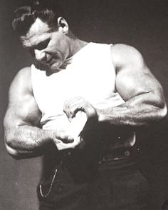 a black and white photo of a man showing off his muscles