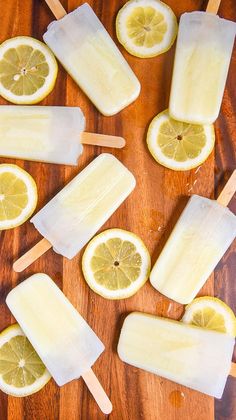 popsicles with lemons and ice on a wooden table next to slices of lemon