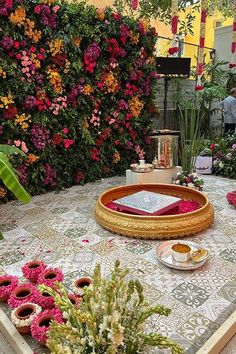 the table is covered with pink and yellow flowers, potted plants and other decorations