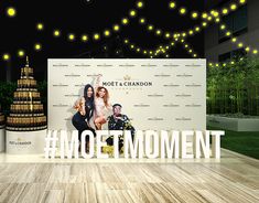 an advertisement for moet & chandon's move to the moment with people standing in front of it