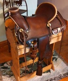 a brown saddle sitting on top of a wooden stand