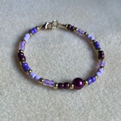 - One Of A Kind Beaded Bracelet - Featuring Light Purple, Dark Purple, And Gold Seed Beads With A White Pearl Bead At The Center - Gold Colored Hardware - Clasps Closed. No Stretch. - Size/ Circumference Is 7” - Handmade (By Myself). Perfect To Treat Yourself Or To Give As A Unique Gift! **Add 2 Jewelry Items Marked “2 For $20” To Your Bundle And I Will Send You An Offer For $20** Tags: Beaded, Handmade Jewelry, Colorblock, Ocean, Pearls Check Out The “Boutique” Tab In My Closet For Handmade Ear Adjustable Purple Bracelets With Tiny Beads, Adjustable Purple Bracelet With Tiny Beads, Single Strand Purple Beads For Gift, Purple Single Strand Beads For Gift, Elegant Hypoallergenic Purple Beaded Bracelets, Purple Single Strand Beads As A Gift, Adjustable Purple Single Strand Jewelry, Elegant Purple Beaded Bracelets With Tiny Beads, Purple Beaded Bracelet With Spacer Beads As Gift