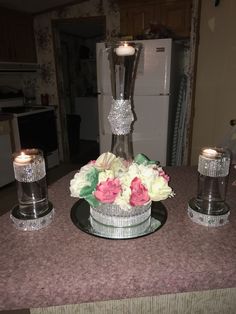 a table topped with candles and flowers on top of a table covered in pink and white flowers