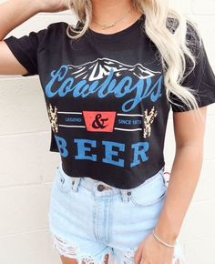 Product Details: - Material: Soft and lightweight 100% cotton - Color: Black crop top with a white and red graphic - Design: Vintage-inspired graphic with "Cowboys and Beer" phrase - Style: Crop top, perfect for pairing with high-waisted jeans or shorts - Fit: Relaxed fit with a cropped length - Size Options: Available in S, M, L, XL - Made and shipped from USA Perfect for your country concert and festivals or adding an edgy touch to your everyday look. Order yours today! Edgy Blue Tops With Graphic Print, Edgy Blue Graphic Print Tops, Crew Neck Top With Letter Print For Concerts, Summer Concert Tops With Logo Print, Crew Neck Tops With Text Print For Concerts, Text Print Crew Neck Top For Concert, Summer Concert T-shirt With Letter Print, Summer Slogan Tops For Concerts, Summer Concert Top With Front Print