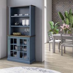 an empty dining room table and chairs next to a blue china cabinet with glass doors