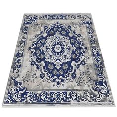 a blue and white rug with an intricate design on the bottom, in front of a white background