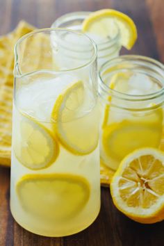 pitcher of lemonade next to sliced lemons