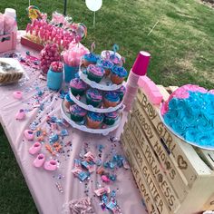 a table topped with lots of cupcakes and other desserts on top of it