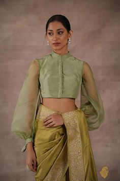 "Whimsical and absolutely fun! This a beautiful and dainty blouse in pure silk with delicate balloon sleeves in pure organza.\u00a0A chic neckline and a delicate line of fabric buttons makes for a\u00a0feminine and fabulous saree accent.\n\u00a0\n\n\n Color - A beautiful\u00a0shade of\u00a0Sage Green\n\n Fabric - Pure Katan Silk body and pure Organza Silk Sleeves\nPlease allow 10-12 business days for despatch.\u00a0\n\n\u00a0\n" Blouse Sleeves Design, Green Blouse Designs, Wedding Saree Collection, Organza Blouse, Organza Sleeves, Romantic Blouses, New Blouse Designs, Indian Saree Blouse, Green Balloon