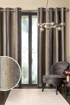 a living room scene with focus on the curtains and chair in front of the sliding glass door