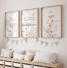 three framed pictures hang on the wall above a wooden bench with pillows and pillow covers